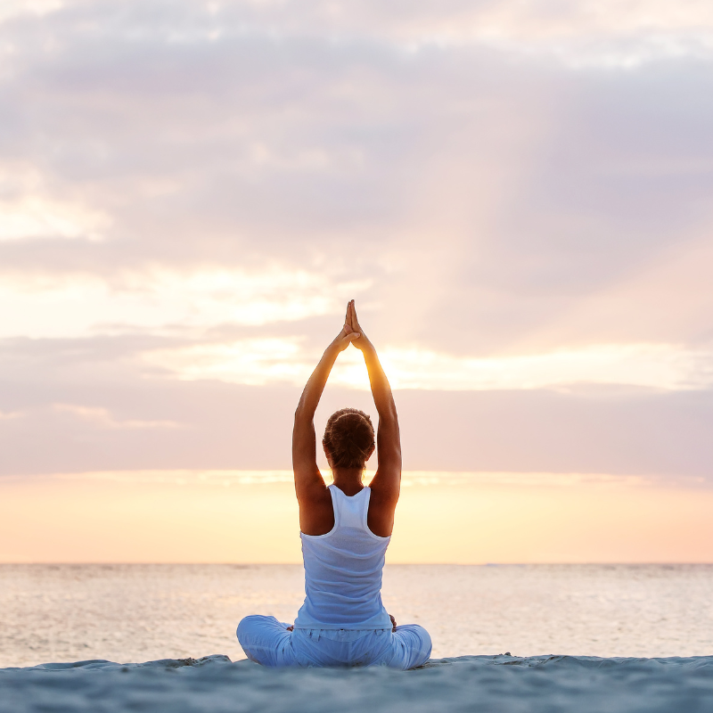 Women, practicing yoga on the beach